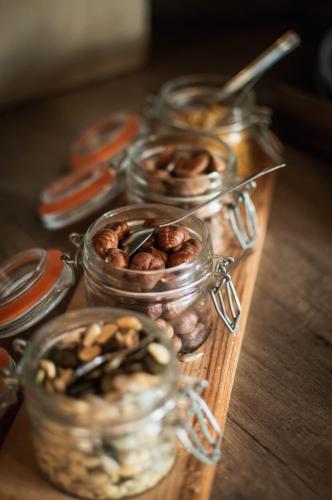 een groep glazen potten gevuld met noten op een tafel bij The Originals City, Hôtel Les Caps, Saint-Brieuc Est in Lamballe