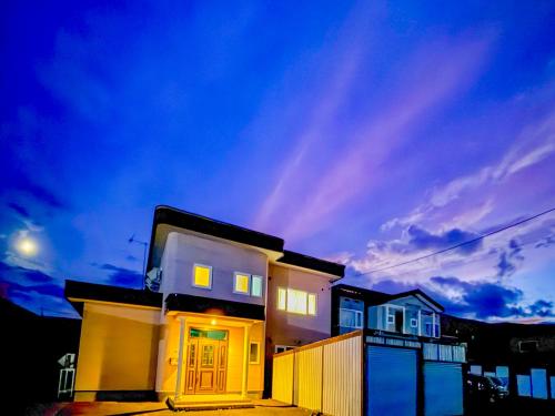a house with the lights on in front of it at Tokinoma Furano in Furano