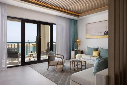 a living room with a couch and a table at Jumeirah Gulf of Bahrain in Manama