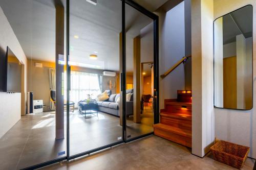 a living room with a couch and a glass door at Tokinoma Furano in Furano