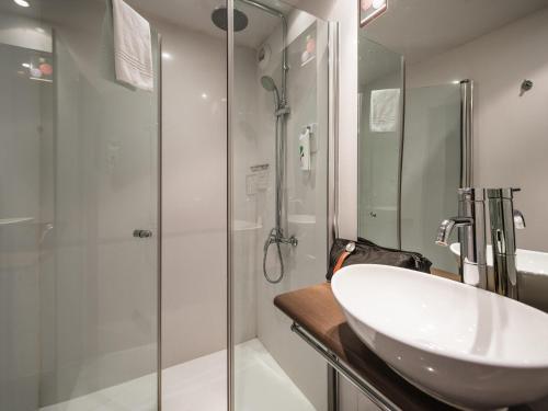 a bathroom with a white sink and a shower at Ibis Styles Toulouse Blagnac Aéroport in Blagnac