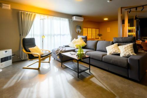 a living room with a couch and a table at Tokinoma Furano in Furano