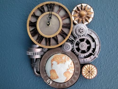 a group of clocks with a map on a wall at Retroversum Themen-Ferienwohnung in Bad Oeynhausen