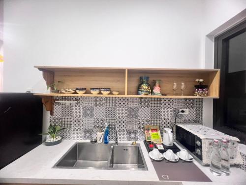 a kitchen counter with a sink and a microwave at Betel Hoi An Homestay in Cam Thanh