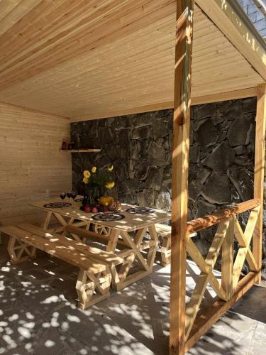 a wooden table in a room with a stone wall at Zghapari Wooden Mountain Lodge in Aspindza