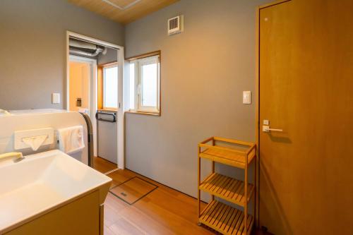 a small bathroom with a sink and a toilet at Tokinoma Furano in Furano