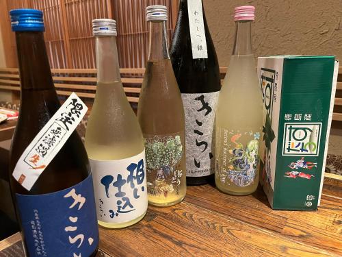 four bottles of wine sitting on a wooden table at 民話の宿荒澤屋旅館 Atasawaya Ryokkan, a inn of folk tales in Okutama