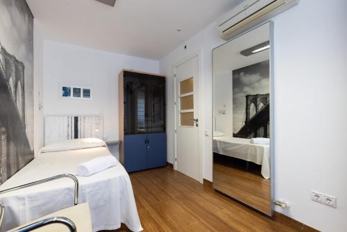 Un dormitorio con una cama y un espejo grande. en TOUS 1 - Only Families, en Salou
