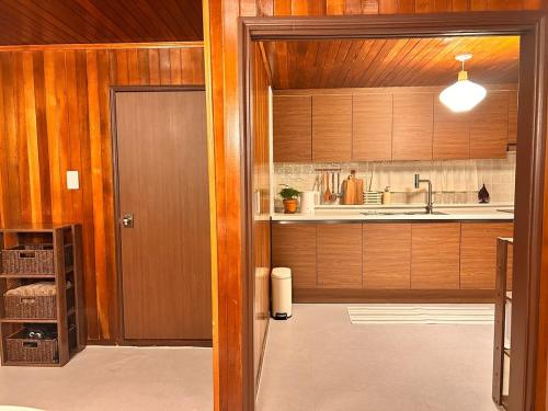 a kitchen with wooden cabinets and a sink at SLOW GWANGAN hotel in Kwangan-dong