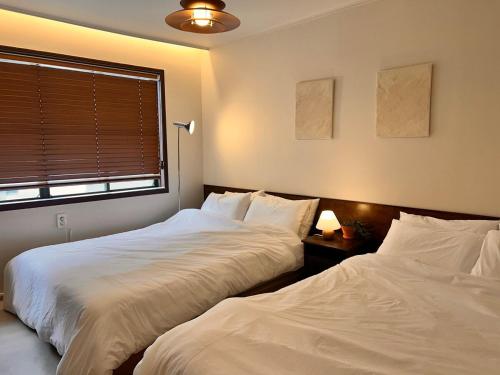 two beds sitting next to each other in a bedroom at SLOW GWANGAN hotel in Kwangan-dong