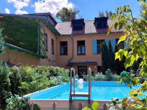 a house with a swimming pool in front of it at Ferienwohnungen Romantika in Potsdam