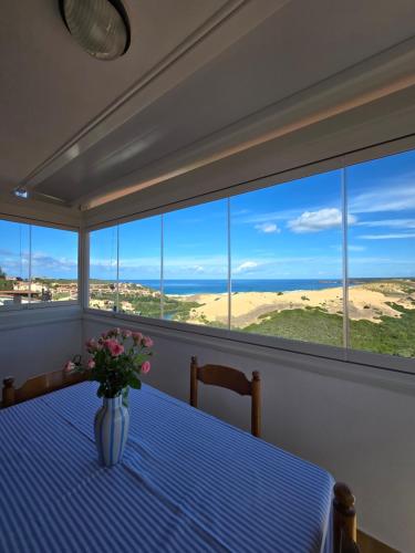 a room with a table with a vase of flowers at Golden Dune View in Torre Dei Corsari