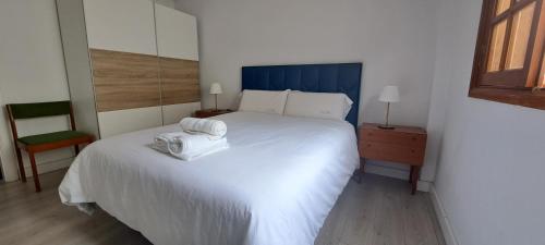 a bedroom with a white bed with a towel on it at VILLA La TOSCA in Vega de San Mateo