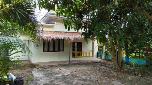a white house with a tree in front of it at The Green Horizon Villa Chaweng Hill in Koh Samui 