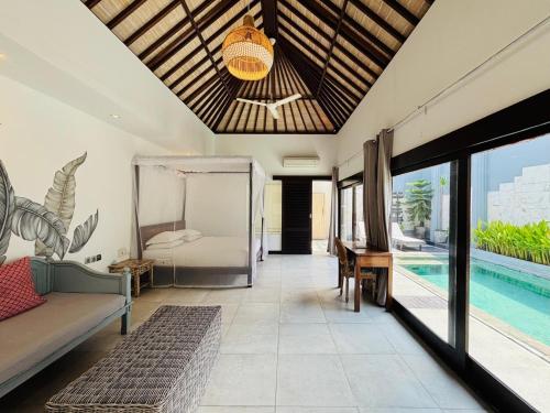 ein Wohnzimmer mit einem Bett und einem Pool in der Unterkunft Zoe Villa Canggu Bali in Canggu