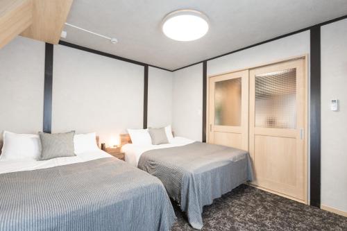 a bedroom with two beds and a closet at b&黒門1号店 in Osaka
