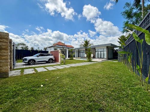 a white car parked in front of a house at Palazzo Carangsari - 2-Bedroom Villa with Private Pool in Payangan