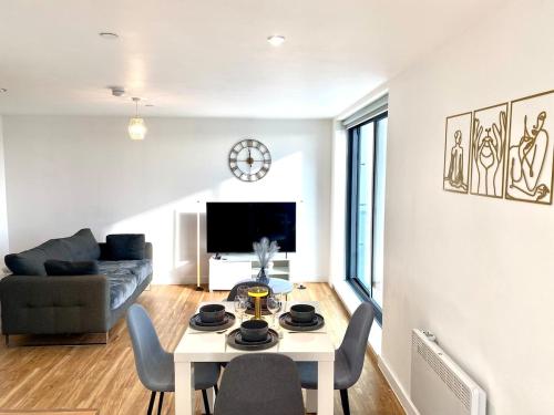 een woonkamer met een tafel en een bank bij Lux Stylish 2 Bed High Rise with Parking and Balcony in Manchester