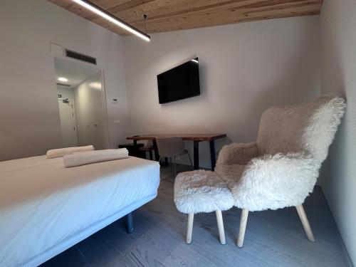a bedroom with a bed and two chairs and a table at Hotel Radona 