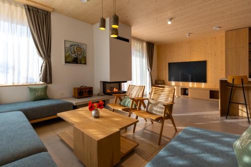 a living room with a couch and a tv at Chalet Bohinj Bliss Wellness and view of Triglav in Bohinj