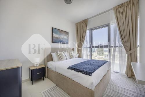 MushayribにあるBloomfields Iconic 2 Br Radiant Boulevard Reemのベッドと大きな窓のある寝室