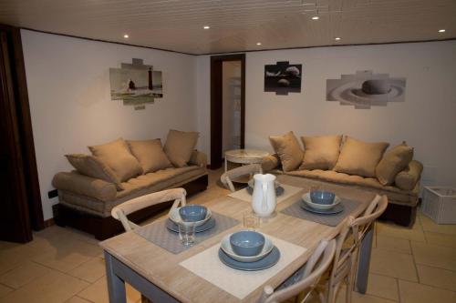 ein Wohnzimmer mit einem Tisch und einem Sofa in der Unterkunft Scisa de lu Fusulicchiu in Lecce