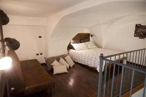 ein Schlafzimmer mit einem Bett und einem Sofa in einem Zimmer in der Unterkunft Scisa de lu Fusulicchiu in Lecce