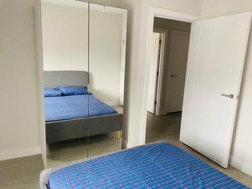 a bedroom with a mirror and a bed in it at Charming 1 Bedroom Flat in the Heart of Uxbridge in Uxbridge
