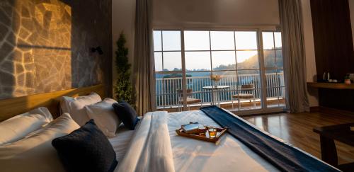 ein Zimmer mit einem Bett und einem großen Fenster mit Aussicht in der Unterkunft The Village Luxury Stay in Jāmb