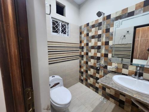 a bathroom with a toilet and a sink at Family Rooms in Johar Town in Lahore