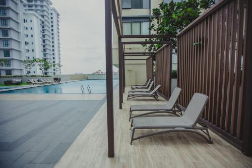eine Reihe von Stühlen neben einem Pool in der Unterkunft Paradigm Residence 4pax TV Box NO Washer Dryer in Johor Bahru