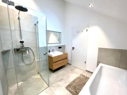 a bathroom with a shower and a sink and a tub at Smart Living Worms in Worms