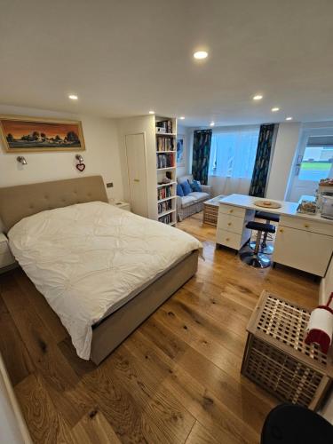 a bedroom with a bed and a desk and a kitchen at The Bungalow Annexe in Northam