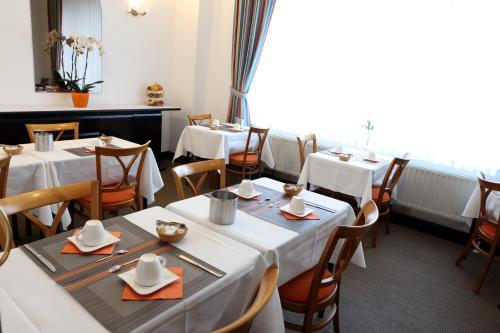 a dining room with white tables and chairs at Eurotel in Liège