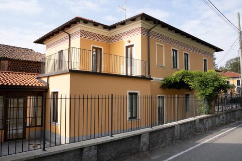 une maison jaune avec une clôture devant elle dans l'établissement Cà del Borgo, à Vizzola Ticino
