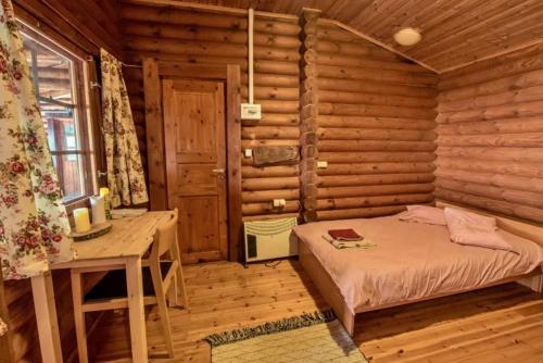 a bedroom with a bed in a log cabin at Pangeo forest village in Mousthéni