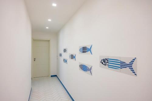 a hallway with blue and white paintings on the wall at Blumare Amalfi Coast in Maiori
