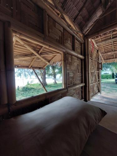 a room with a bed with a window and a view at Samui Camping Farm in Laem Sor