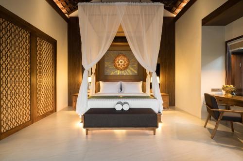 a bedroom with a bed with a canopy at Sanggraloka Ubud in Ubud