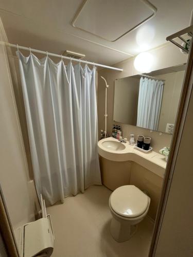 a bathroom with a toilet and a sink and a mirror at Vacation House Kawaraya in Senboku