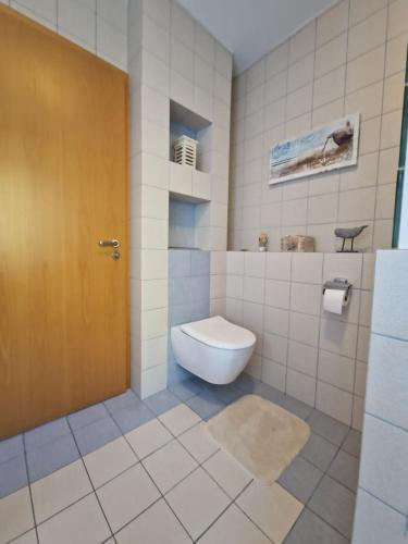 シュヴェットにあるFerienhaus Hasenhügel mit Seeblickのバスルーム(トイレ付)、茶色のドアが備わります。