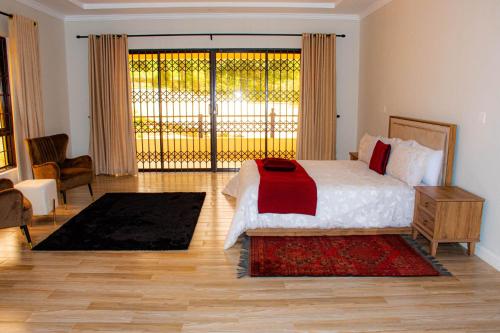 a bedroom with a bed and a large window at Ekom Nest in Musereita