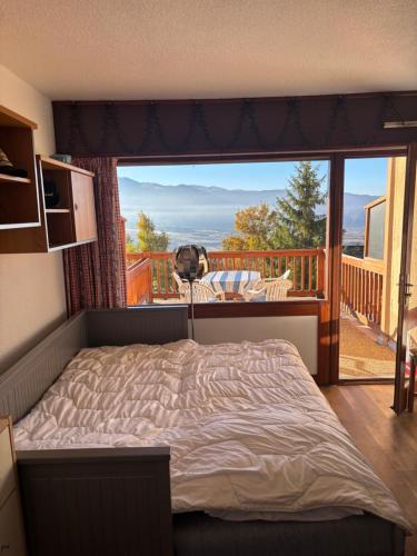 a bedroom with a bed in front of a large window at Le cocon du Canigou in Font-Romeu