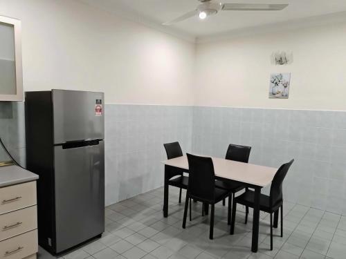 a kitchen with a table and chairs and a refrigerator at Be Stay Ipoh with parking - 14pax, 5Rooms in Ipoh