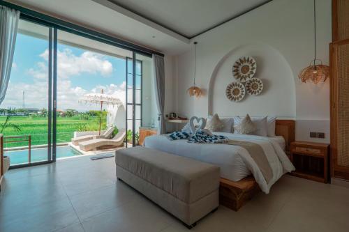 a bedroom with a large bed and a large window at The Alvarendra Ubud Villa By Bali Cabin in Ubud