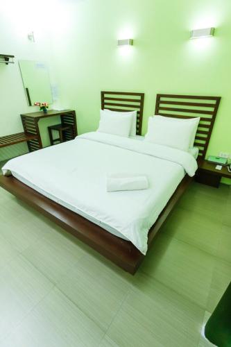 a bedroom with a large bed with white sheets at S Hotel Kanchanaburi in Kanchanaburi
