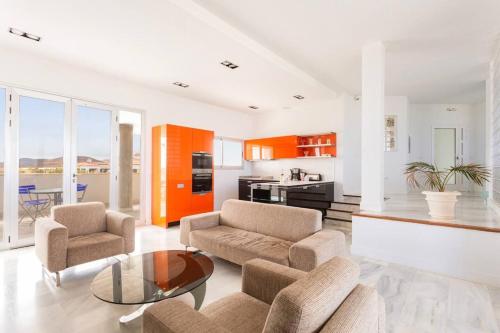 ein Wohnzimmer mit zwei Stühlen und einem Tisch in der Unterkunft Amarilla Golf Villas-lovely Complex-amazing View in San Miguel de Abona