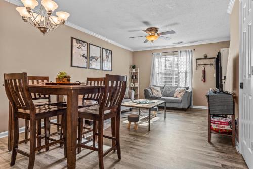 a dining room and living room with a table and chairs at Woodstone Retreat right next to UGA golf course in Athens
