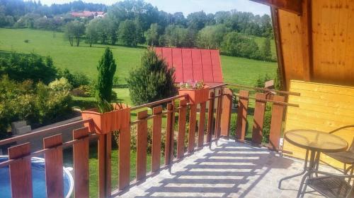 a balcony of a house with a view of a field at Chata Wellness Březka in Libuň