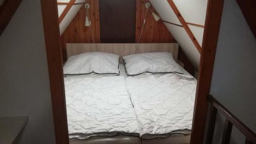 a small bed with two pillows in a room at Chata Wellness Březka in Libuň